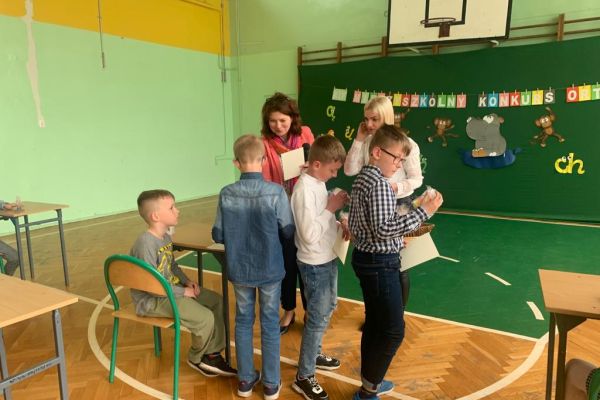 Uczniowie otrzymują dyplomy za udział i upominki.