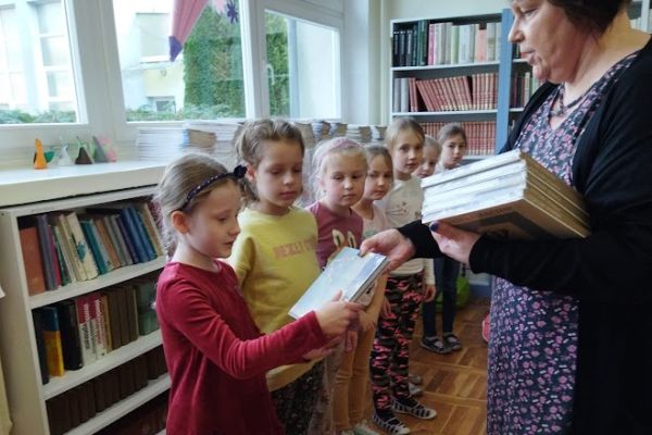 Pani Halina Hołowienko wręcza uczennicy książkę