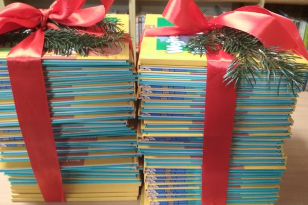 Książki od Pani Prezydent i Pani Wiceprezydent obwiązane czerwoną wstążką i ozdobione gałązkami świerku