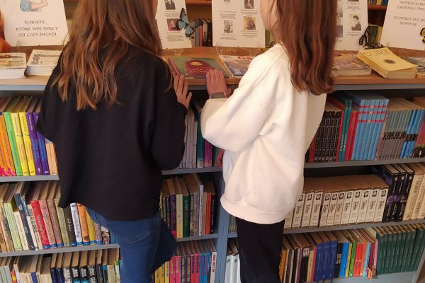 Uczennice oglądają wystawkę tematyczną