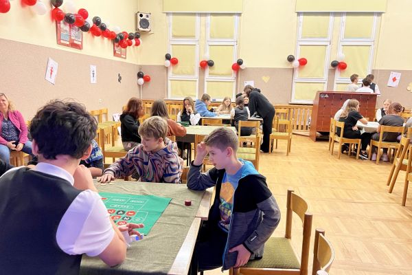 Uczniowie klas 7 przy stołach do gry