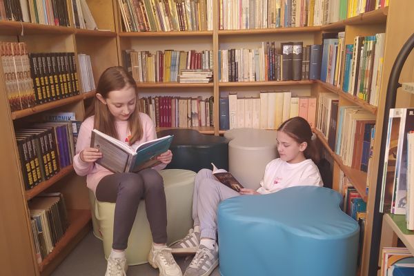 Uczennice czytają książki w nowym kąciku czytelniczym 