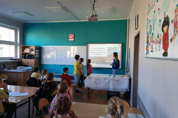 Dzieci rozwiązują zadania przy tablicy multimedialnej