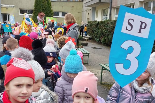 Dzieci trzymają tarczę szkoły